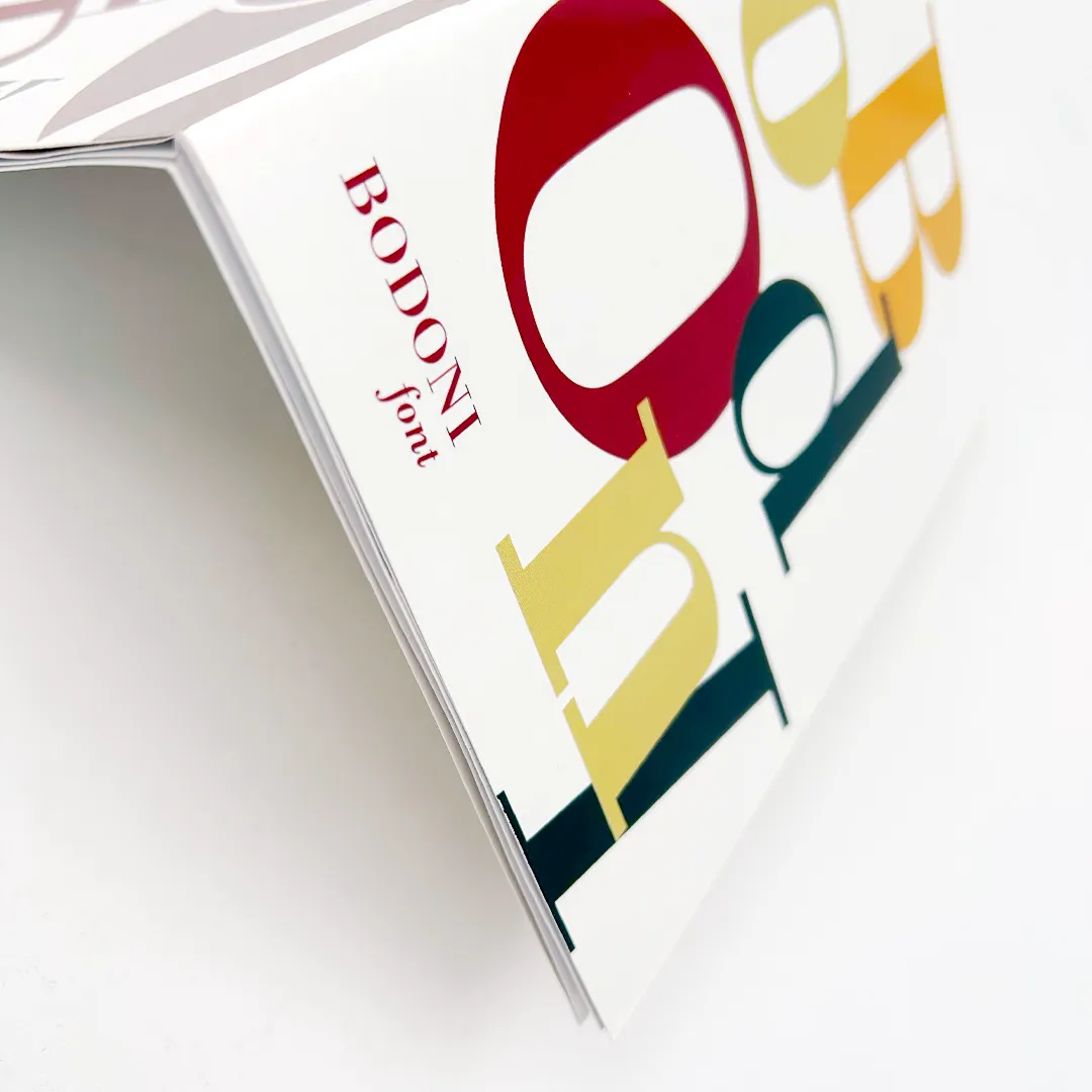 Publicación Bodoni sostenida en mano — detalle de acabado